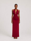 A woman wearing the Elévaison Vivienne burgundy deep V-neck halter maxi dress with a ruched waist, viewed from the front, against a light gray studio background.