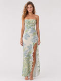 A woman wearing the Elévaison Liora Botanical Mist strapless high-low maxi dress with a ruffled hem, viewed from the front, against a light gray studio background.