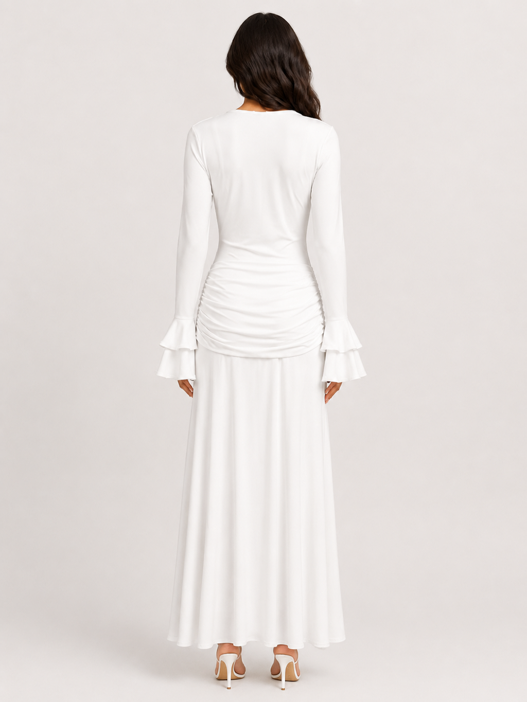 A woman viewed from the back wearing the Elévaison Odette white lace-trim cutout long-sleeve maxi dress, against a light gray studio background.