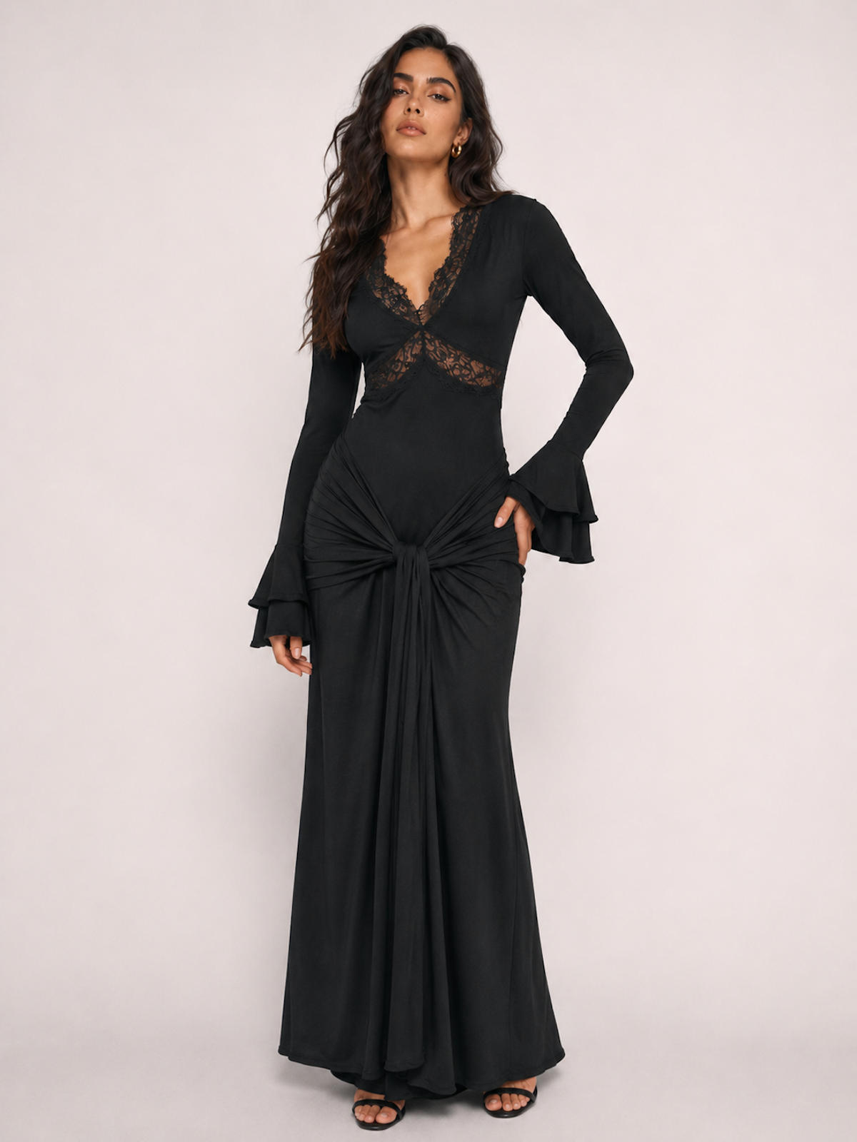 A woman wearing the Elévaison Odette black lace-trim cutout long-sleeve maxi dress, viewed from the front, against a light gray studio background.
