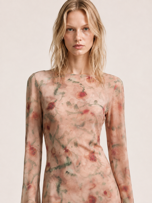 Close-up of a woman wearing the Elévaison Rosy Blushed Garden watercolor-floral bell-sleeve mini dress, showing the bodice, against a light beige studio background.