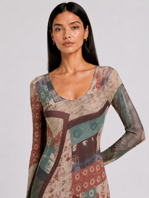 A woman modeling a long-sleeve scoop-neck top with an abstract patchwork print in beige, brown, teal, and muted red tones, photographed against a light gray studio background.