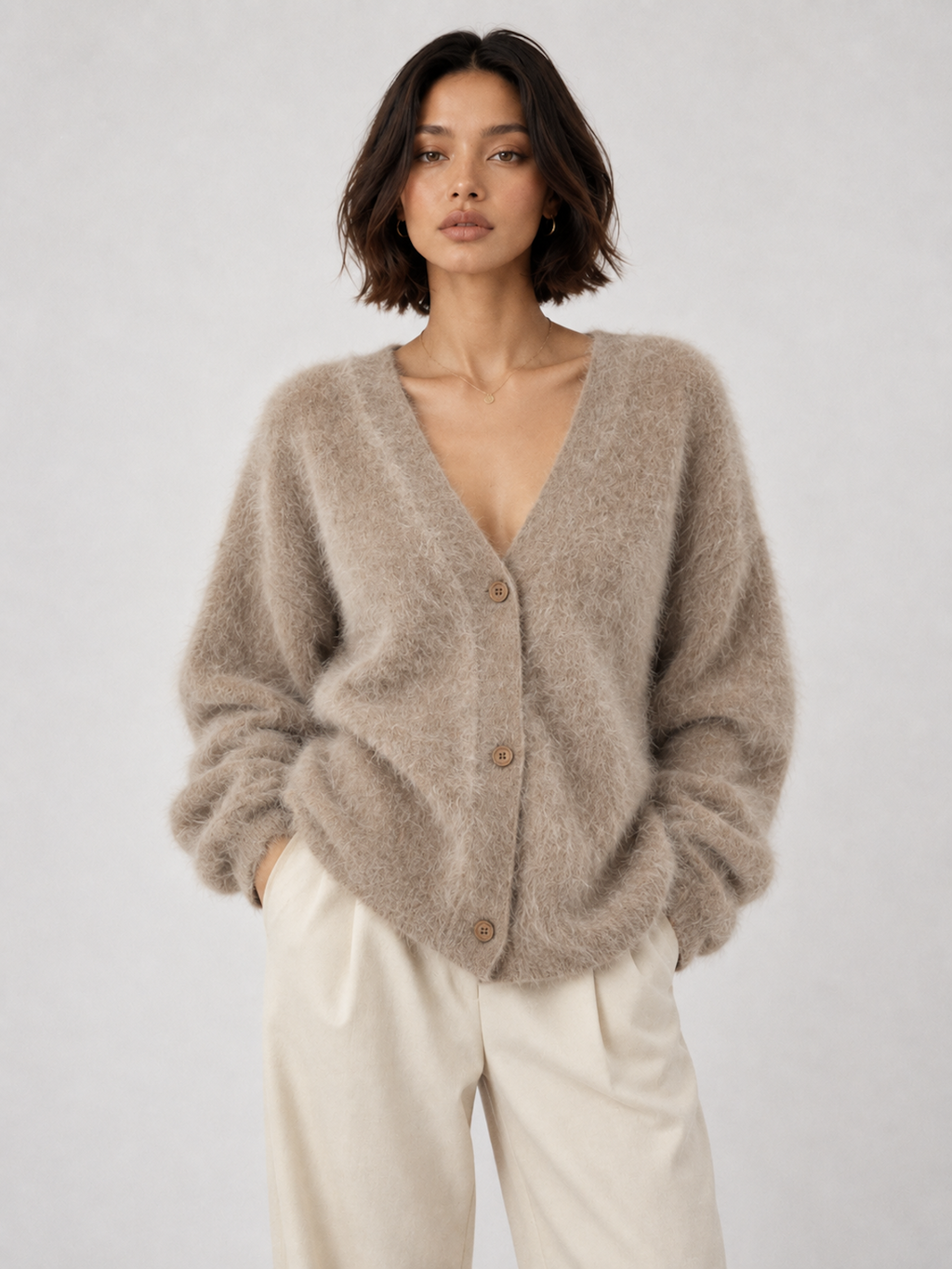 Model wearing the Khaki Elévaison Alina Cardigan with a V-neck button front and ribbed trim against a pale gray studio backdrop.