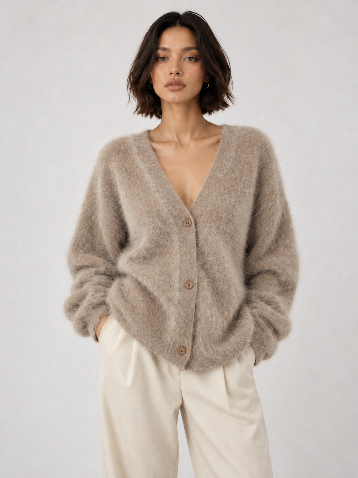 Model wearing the Khaki Elévaison Alina Cardigan with a V-neck button front and ribbed trim against a pale gray studio backdrop.