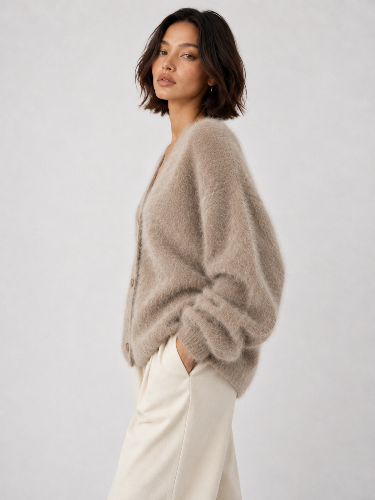 Model wearing the Gray Elévaison Alina Cardigan with a relaxed button-front silhouette and ribbed trim in a pale gray studio.
