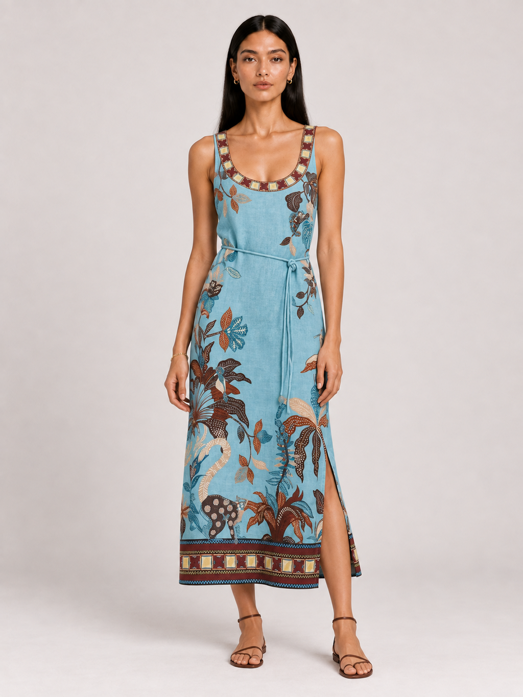 Model wearing the Botanical Lagoon Elévaison Daria Dress with a scoop neck, tie waist and floral border print in studio.