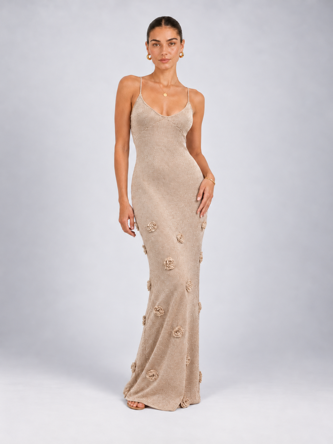 Front view of the apricot Elévaison Sabella Dress with a fitted maxi silhouette and floral appliqués against a light gray seamless backdrop.