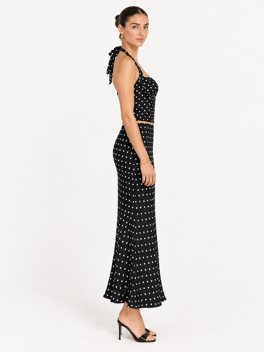 Side view of the Midnight Polka Elévaison Thalia Two Piece with an exposed waistline and fitted flared skirt in studio.