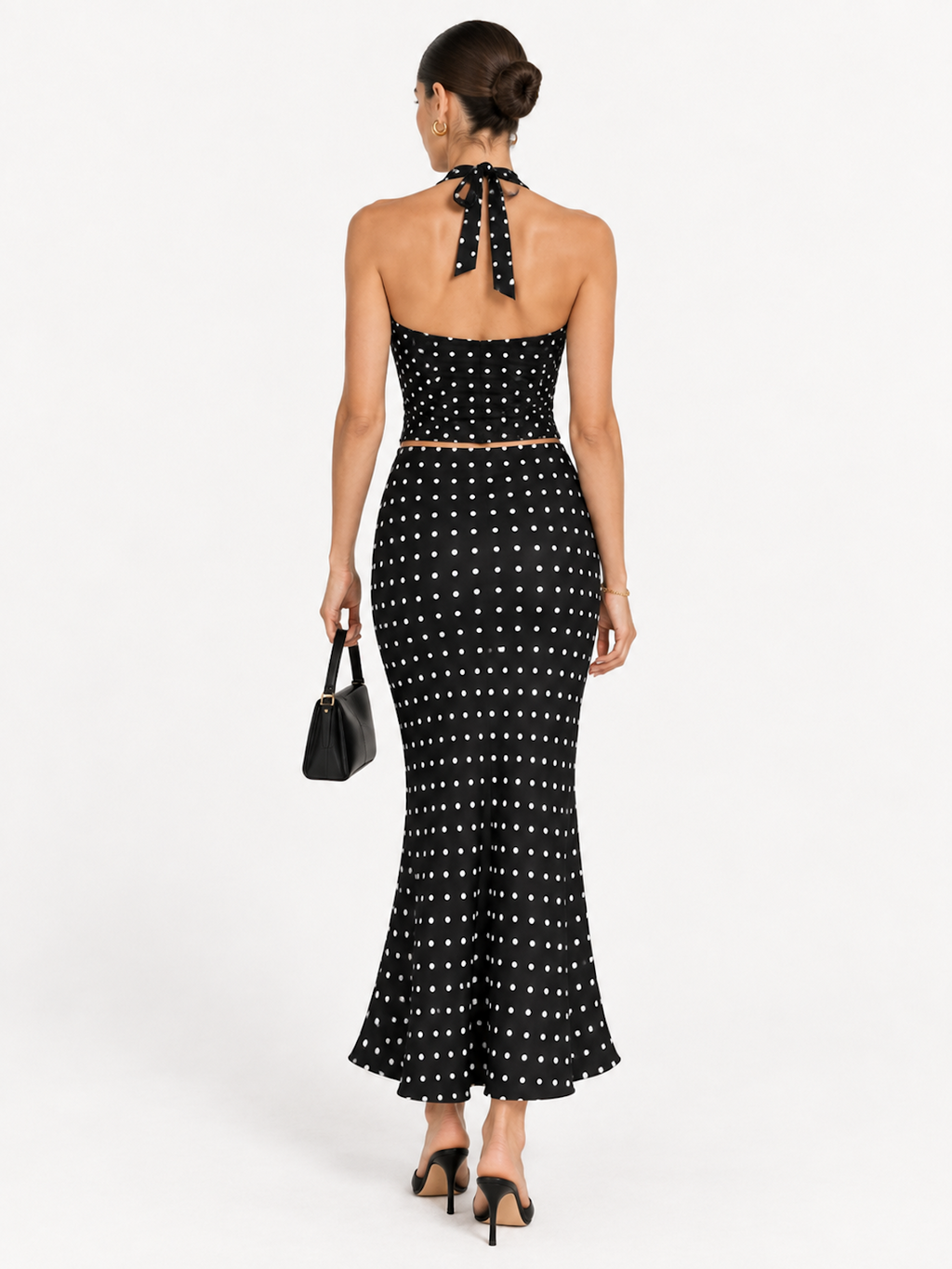 Back view of the Midnight Polka Elévaison Thalia Two Piece, showing the halter tie and flared midi skirt in studio.