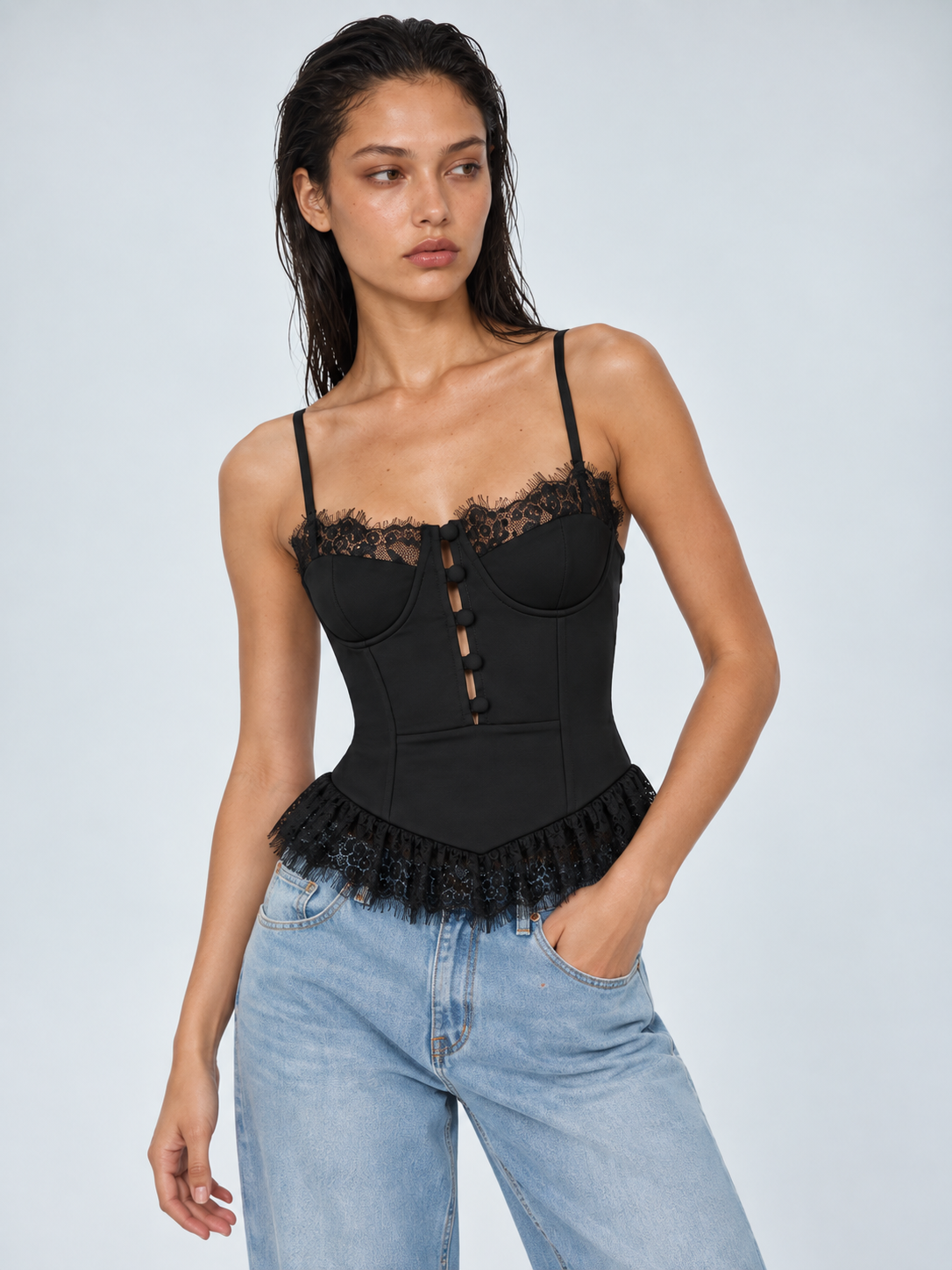 Elévaison Belle Tank Top in black, close-up front view showing lace trim, shaped cups and front button detail against a pale blue studio background.