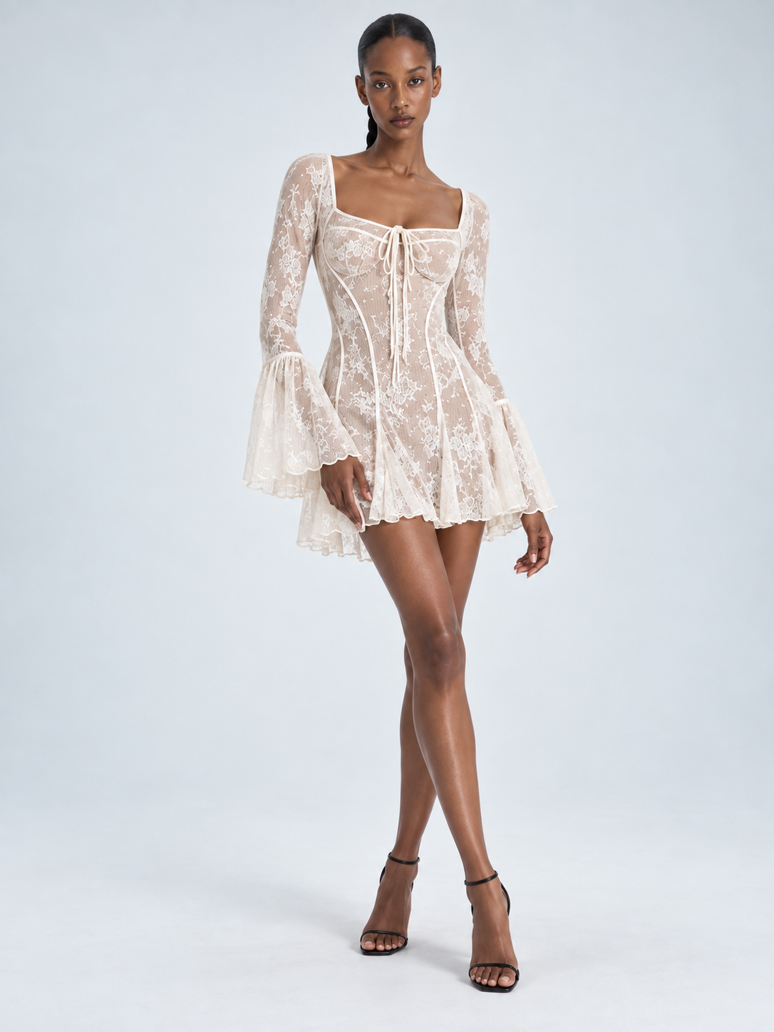 Elévaison Estelle Dress in white, full-length front view showing a square neckline, lace sleeves and flared mini skirt against a pale blue studio background.