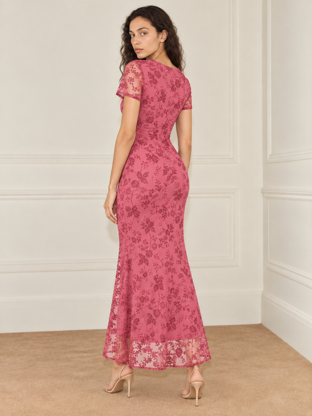 Elévaison Juliette Dress in pink, back view showing the fitted silhouette, short sheer sleeves and sheer floral hem against a warm cream paneled studio background.