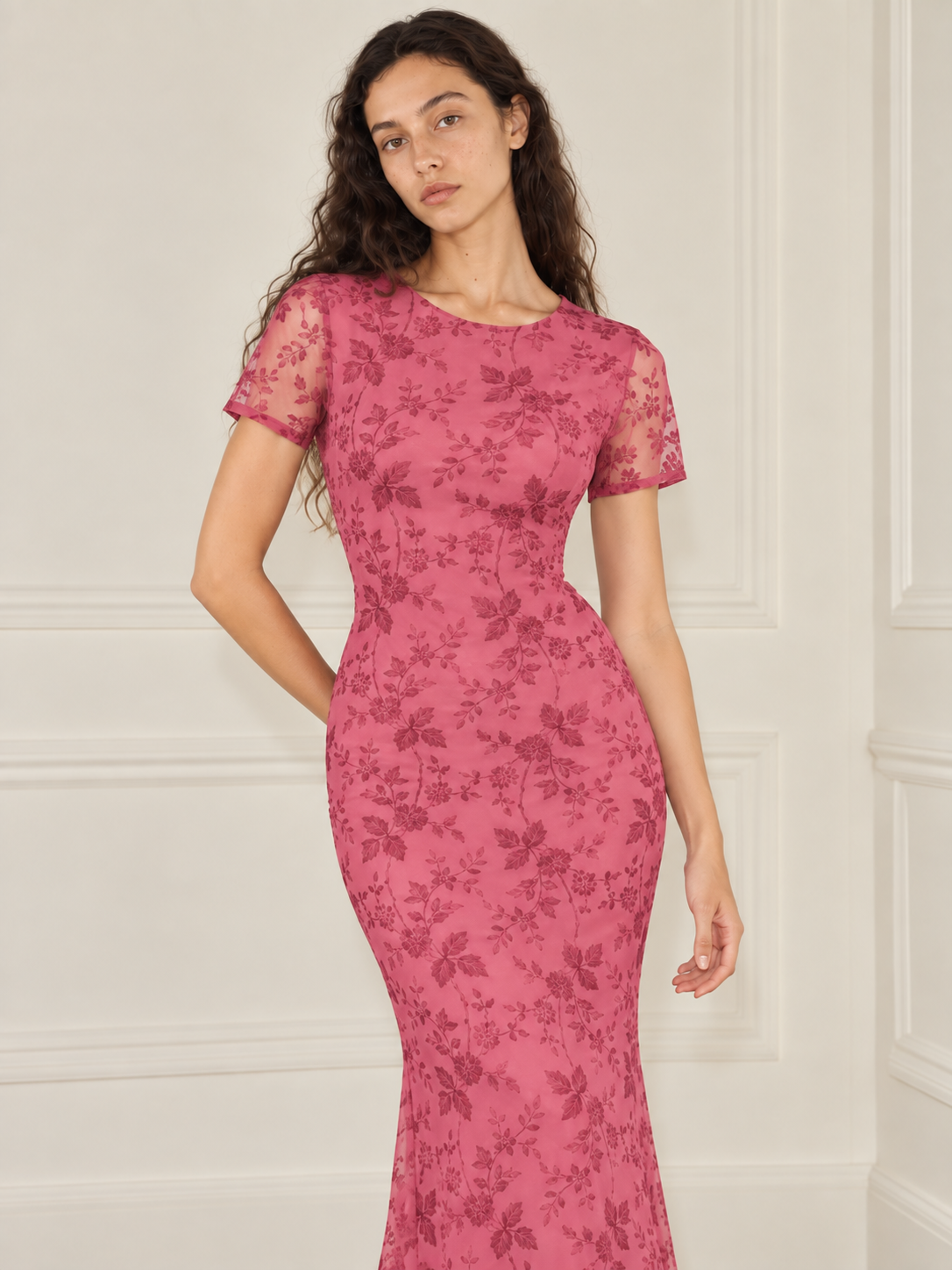 Elévaison Juliette Dress in pink, close-up front view showing the floral overlay and sheer short sleeves against a warm cream paneled studio background.