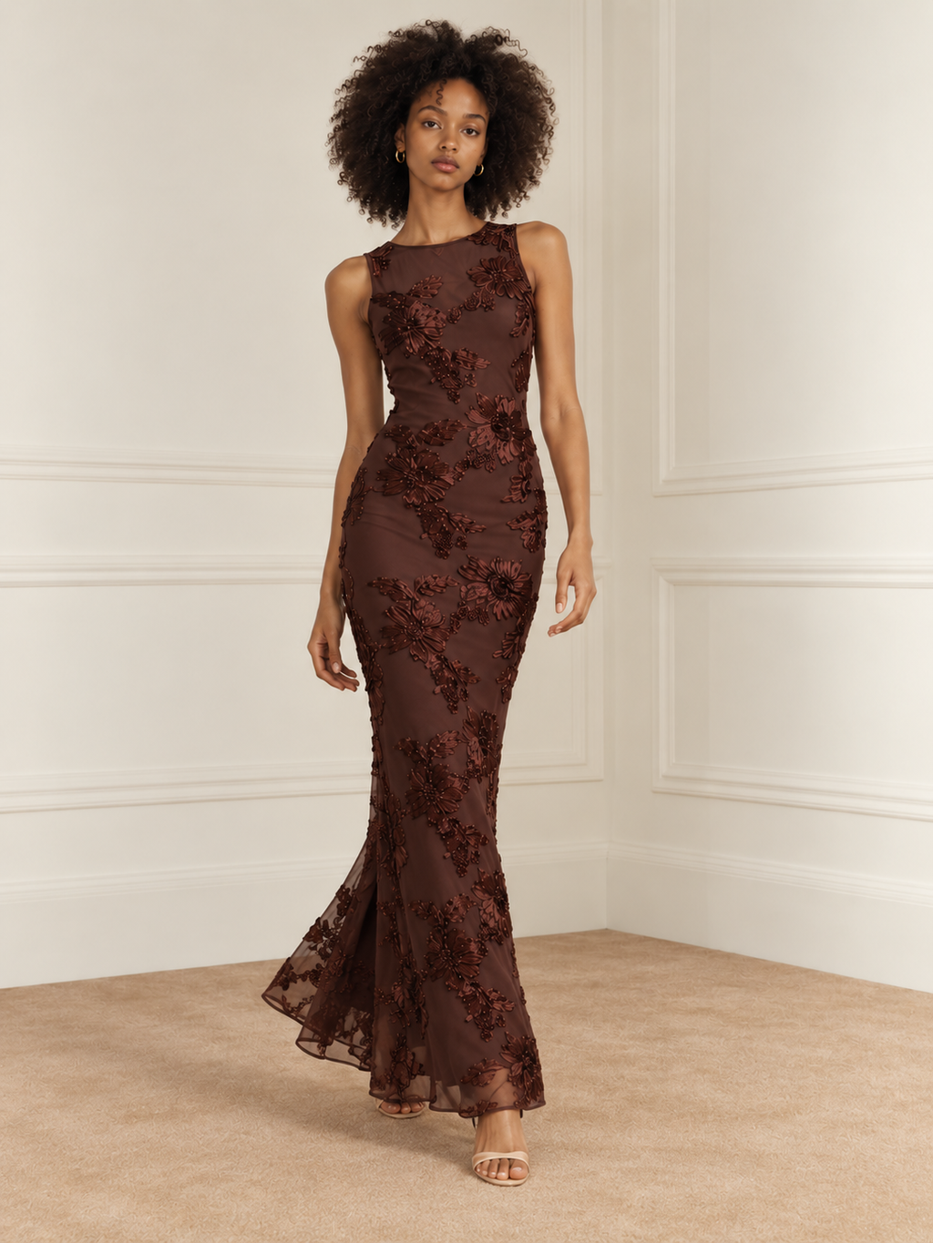 Elévaison Grace Dress in chocolate brown, full-length front walking view showing a sleeveless fitted silhouette and dimensional floral embroidery against a warm cream paneled studio background.