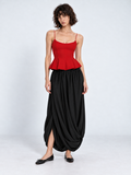 A model wears the Elévaison Gabrielle Skirt in Black, with sweeping drapes and an open front hem against a light gray backdrop.