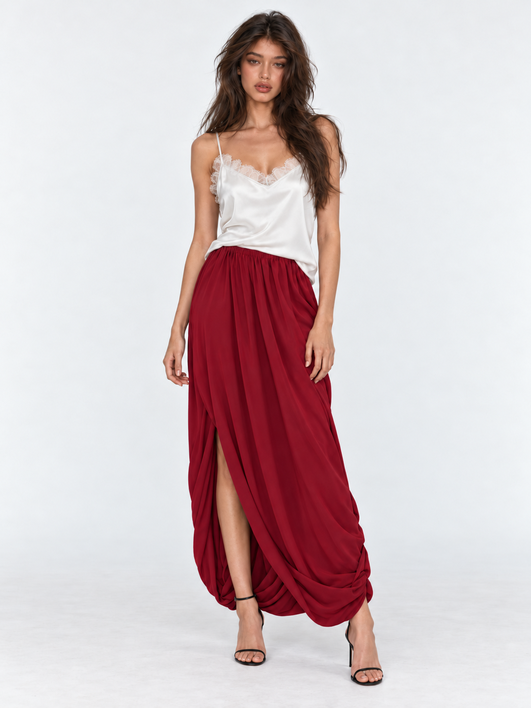 A front view of the Elévaison Gabrielle Skirt in Burgundy shows its gathered waist and draped hem against a light gray backdrop.
