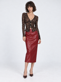 A model wears the Elévaison Bianca Skirt in Burgundy with a leopard cardigan, showing its midi length against a light gray backdrop.