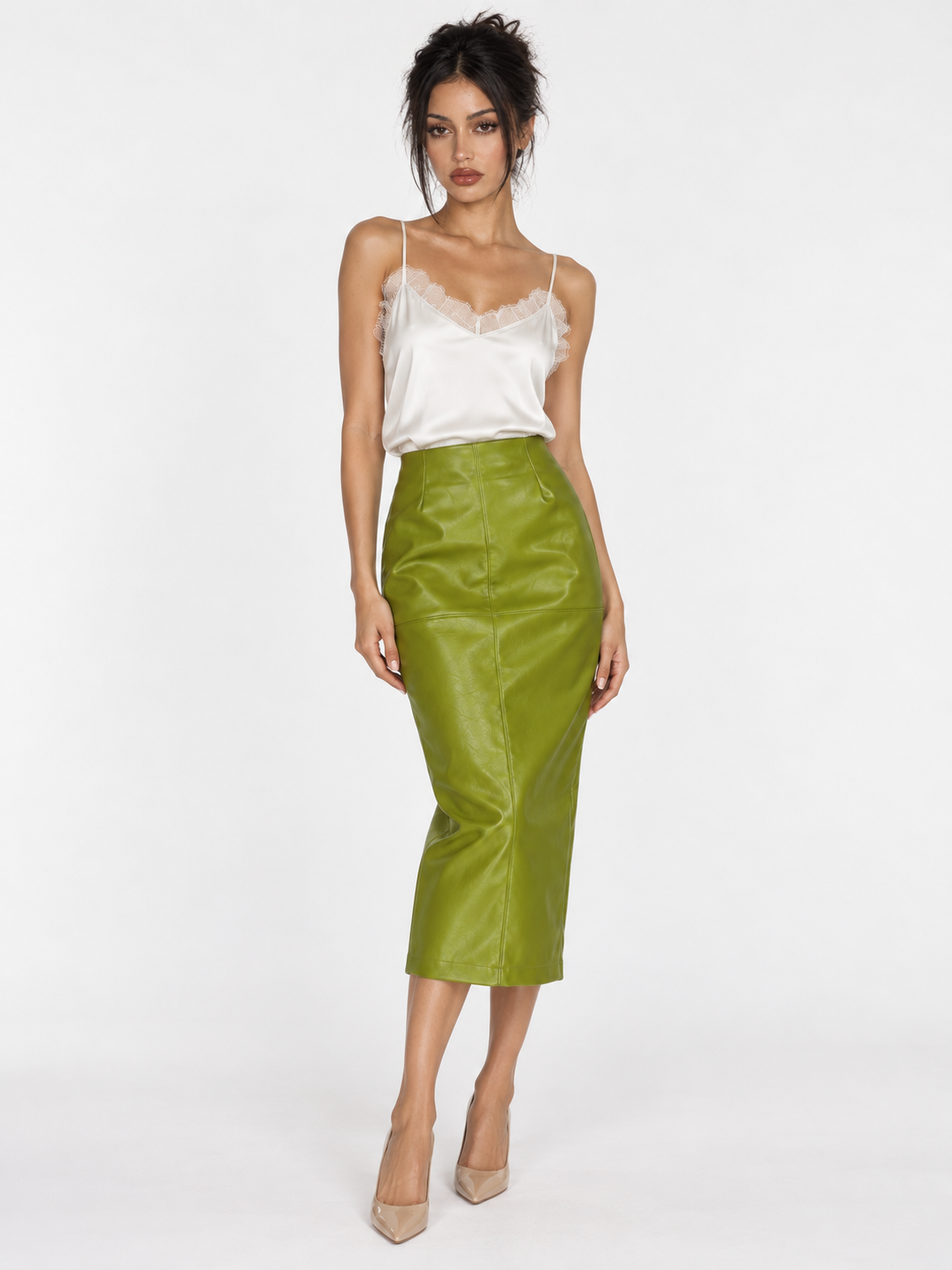 A model wears the Elévaison Bianca Skirt in Green with a white camisole, showing its glossy surface against a light gray backdrop.