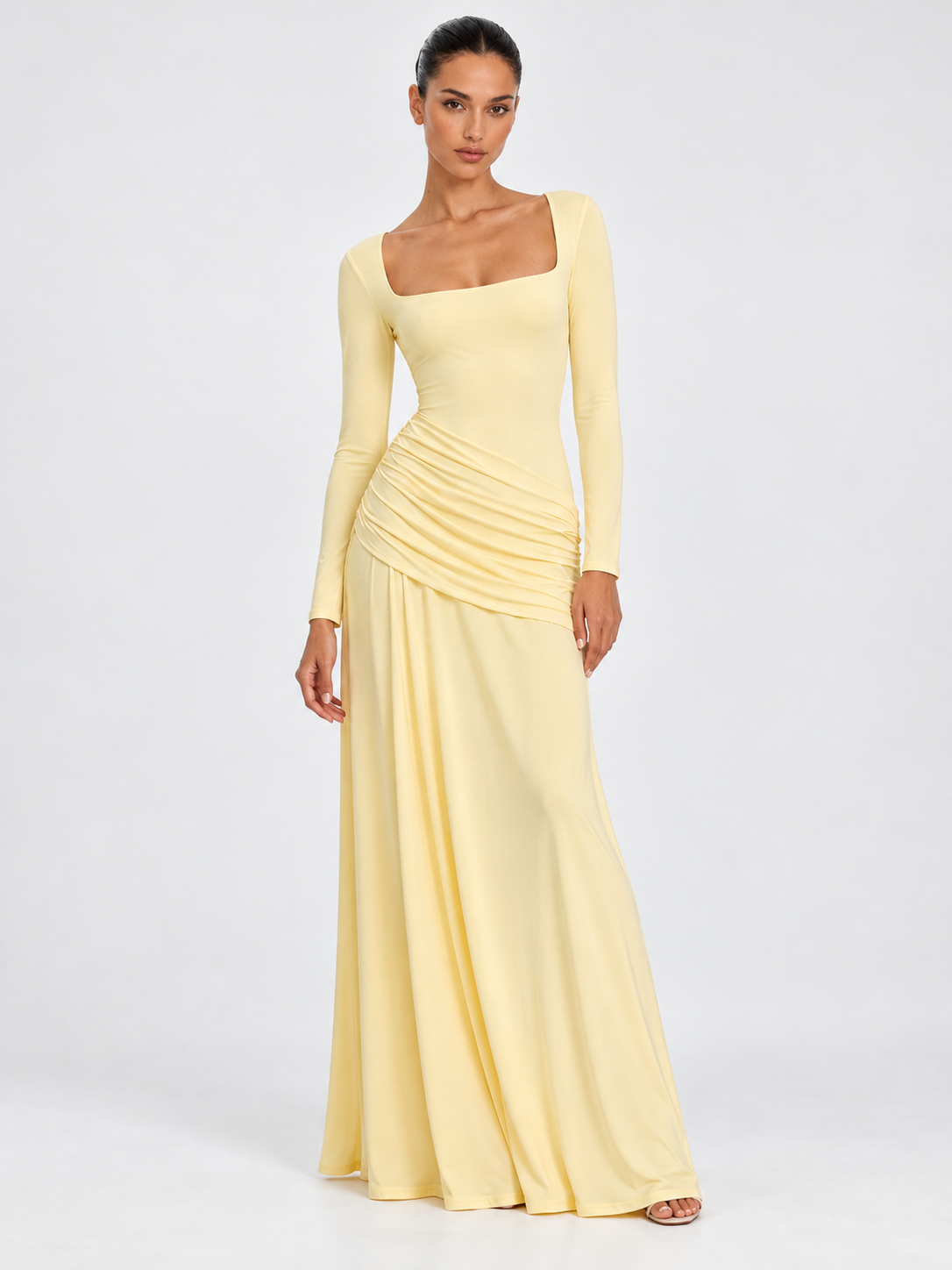 A model wears the Elévaison Arabella Dress in Light Yellow, with a square neckline and gathered hips against a light gray backdrop.