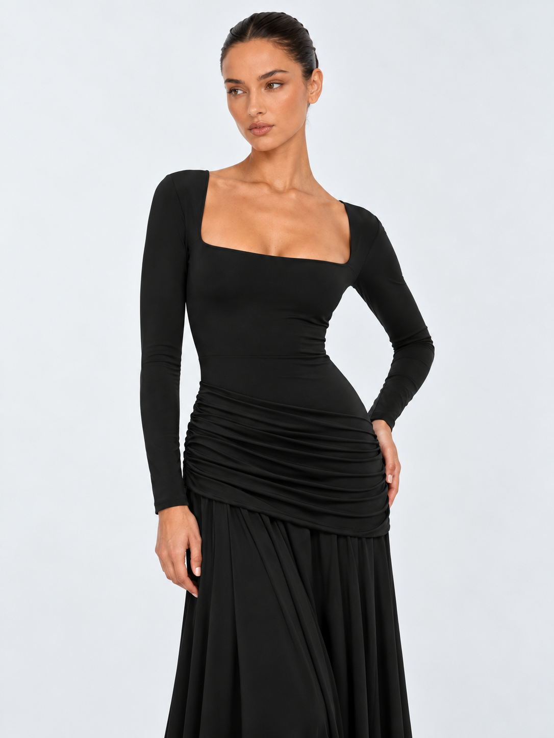 A closer view of the Elévaison Arabella Dress in Black shows its square neckline and long fitted sleeves against a light gray backdrop.