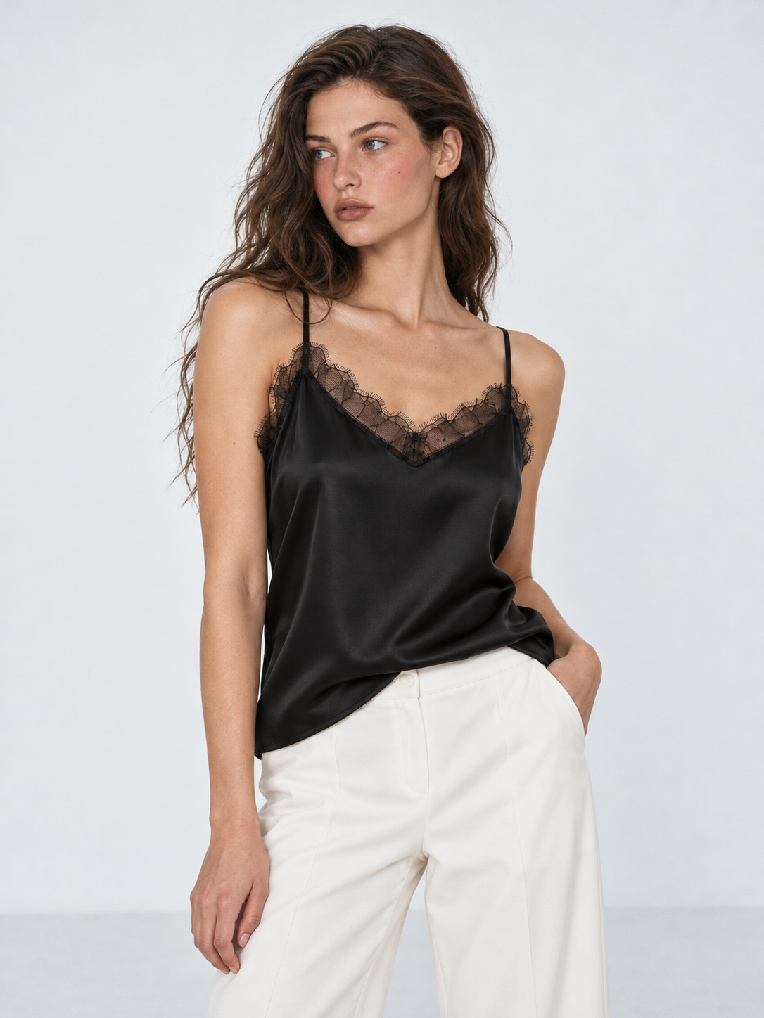 A closer view of the Elévaison Anya Silk Camisole in Black shows its lace V-neck and fluid drape against a light gray backdrop.
